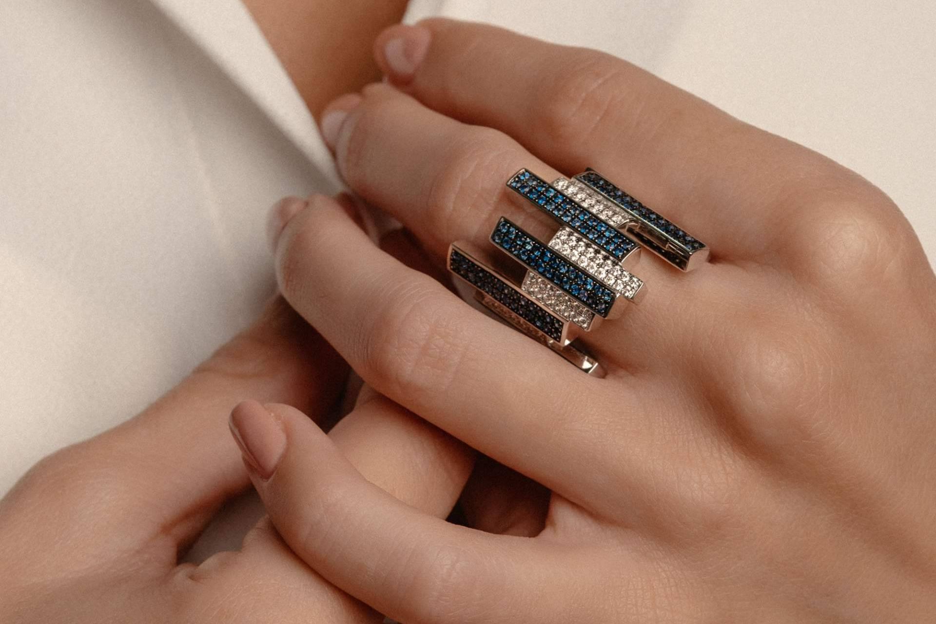 Elegancia cromática en la mano; anillo con esmeralda y anillos con zafiros